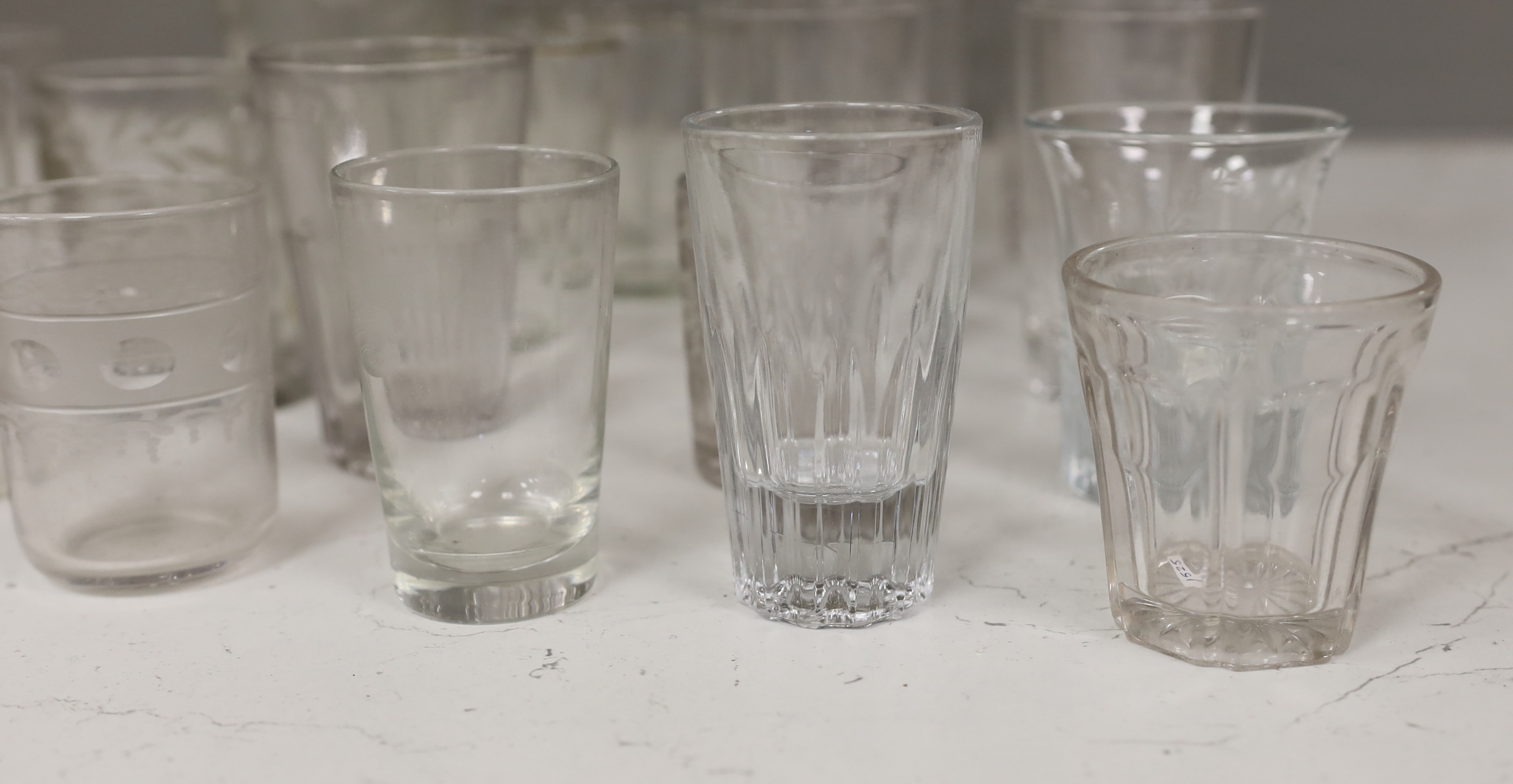A collection of 19th and early 20th century drinking glasses, including beakers, some etched examples, half pint ale mug, an etched glass jug, etc., tallest 17cm (20)